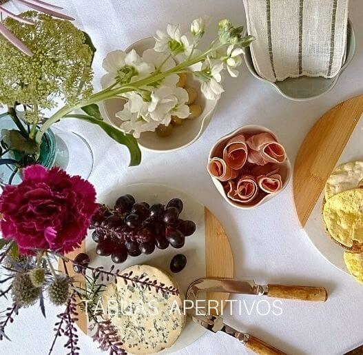 Mesa posta elegante com tábuas de aperitivos e decoração floral, Para La Casa